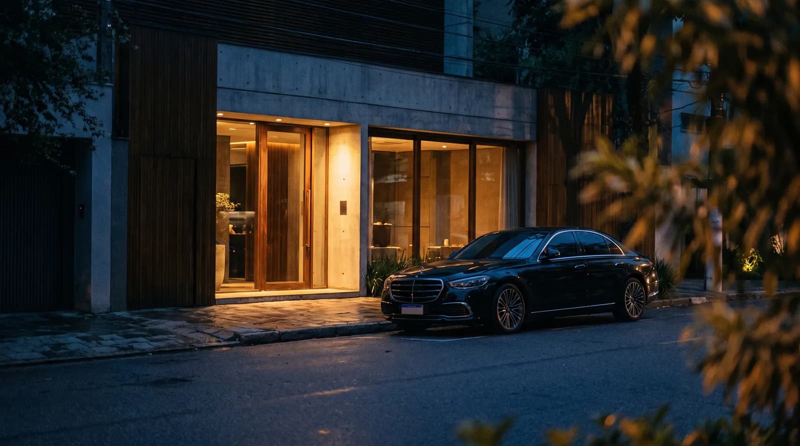Discreet sedan holding at an upscale São Paulo restaurant entrance at night.